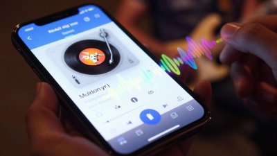 Smartphone identificando música com ondas sonoras coloridas.