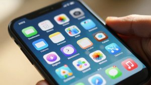 Tela de celular com ícones de aplicativos populares.